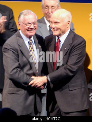 Pionieri spaziali Neil A. Armstrong e John H. Glenn condividono un abbraccio come essi sono introdotti durante la dedicazione del Museo Nazionale dell'aria e dello spazio di Steven F. Udvar-Hazy Center di Chantilly, Virginia su dicembre 11, 2003. Armstrong ha volato a razzo X-15 piano, era il comandante della missione per la Gemini 8 e il 20 luglio 1969, come comandante della missione Apollo 11, ws il primo uomo a camminare sulla luna. Glenn è diventato il primo americano in orbita attorno alla Terra il 20 febbraio 1962. Successivamente, ha servito come un senato degli Stati Uniti da Ohio ed era una specialista di missione sullo Space Shuttle STS-95 missi Foto Stock