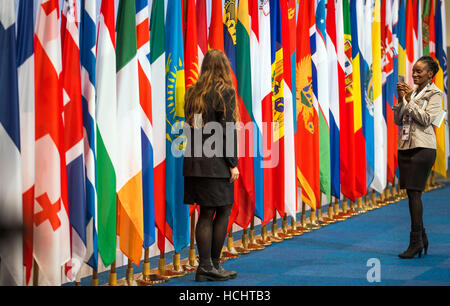 Amburgo, Germania. Il 9 dicembre, 2016. Due membri della delegazione di scattare foto di fronte alle bandiere degli Stati membri in occasione del Consiglio Ministeriale OSCE presso i padiglioni di Amburgo, Germania, 9 dicembre 2016. Circa 50 ministri degli affari esteri di partecipare alla conferenza dell'Organizzazione per la sicurezza e la cooperazione in Europa tra il 8 e il 9 dicembre a Amburgo. Foto: Jens Büttner/dpa-Zentralbild/dpa/Alamy Live News Foto Stock