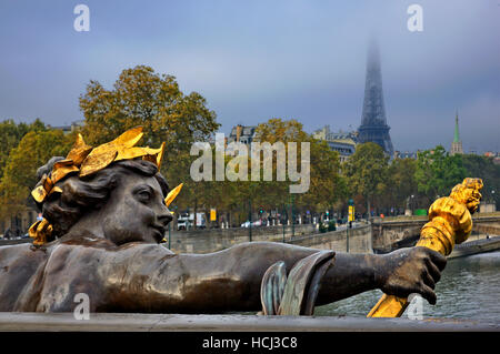 Scultura su Pont Alexandre III, Parigi, Francia. Sullo sfondo la torre Eiffel nascosto tra le nuvole Foto Stock
