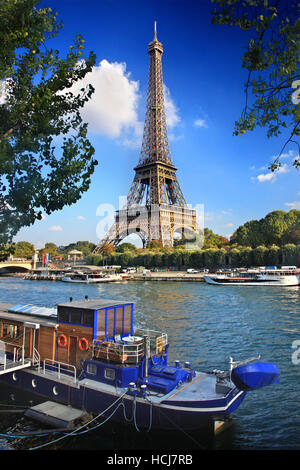 Vecchio riverboat utilizzato come residenza sul fiume Senna, Parigi, Francia. Sullo sfondo la torre Eiffel. Foto Stock