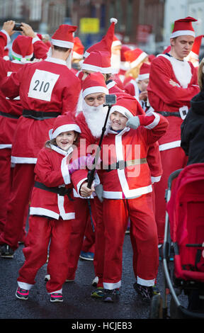 Una famiglia vestiti da Babbo Natale prendendo un selfie foto, Winchester Hampshire England Regno Unito Foto Stock