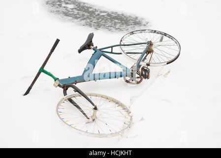 Vecchio rotto bike giacente nella neve Foto Stock