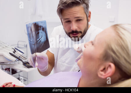 Dentista mostra raggi x al paziente Foto Stock
