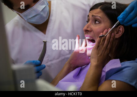 Paziente femmina spaventata durante un dentista di check-up Foto Stock