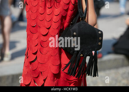 Donna con abito rosso e V 73 zaino nero con frange prima Stella Jean fashion show, la Settimana della Moda Milanese street style, 2016 Foto Stock