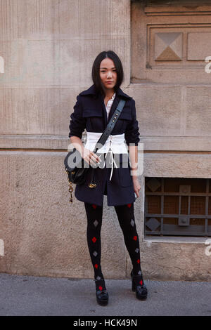 Donna con in bianco e nero e abiti in pelle nera borsa prima di Prada fashion show, la Settimana della Moda Milanese street style Foto Stock