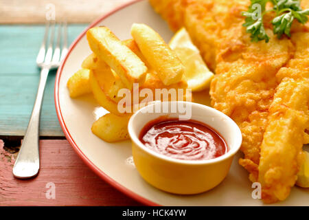 Fritte martoriata pesce su una piastra con chips close up Foto Stock