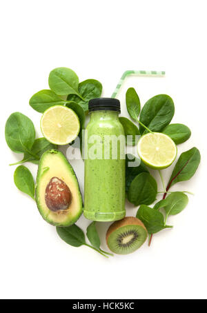 Imbottigliato detox drink circondati dal verde alimenti compresi gli spinaci e kiwi Foto Stock