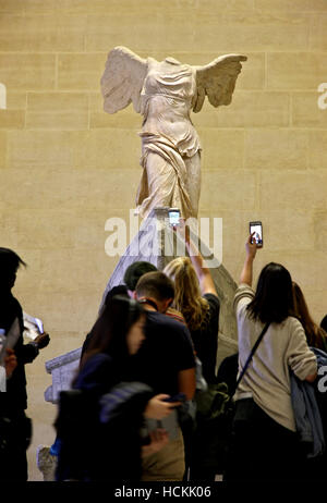 I visitatori si sono riuniti di fronte alla egli 'Vittoria Alata ("Nike') di Samotracia", il museo del Louvre di Parigi, Francia. Foto Stock