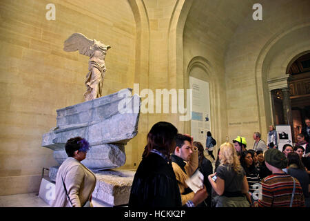 I visitatori si sono riuniti di fronte alla egli 'Vittoria Alata ("Nike') di Samotracia", il museo del Louvre di Parigi, Francia. Foto Stock