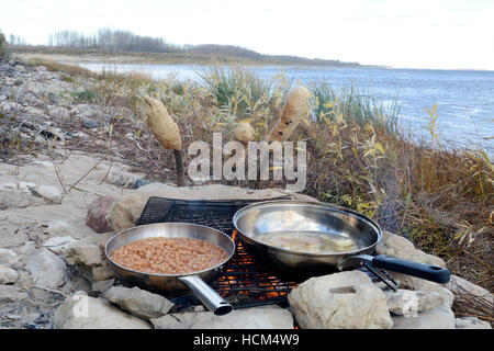 Bannock su un bastone, nativo North American food simile al pane cotti su un falò nel nord Ontario, Canada. Foto Stock