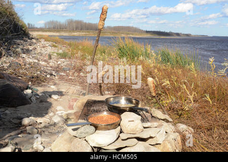 Bannock su un bastone, nativo North American food simile al pane cotti su un falò nel nord Ontario, Canada. Foto Stock