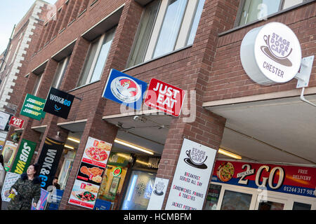 Linea di caffè e takeaways, cartello Just Eat e aziende nel centro storico di Chester, Inghilterra, Regno Unito. Foto Stock