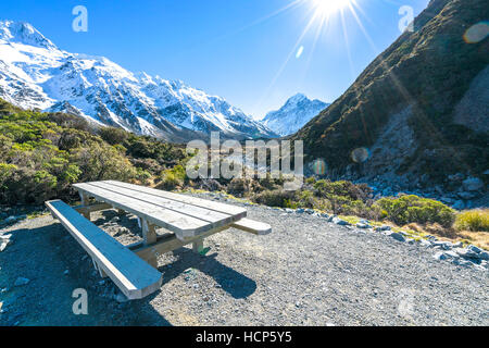 Appoggio tavoli e le sedie in legno con sun flare a Mount Cook, Nuova Zelanda Foto Stock