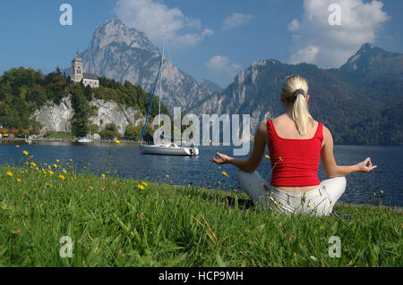 Giovane donna bionda di relax presso il lago Traunsee, Salzkammergut resort area, Austria superiore, Europa Foto Stock