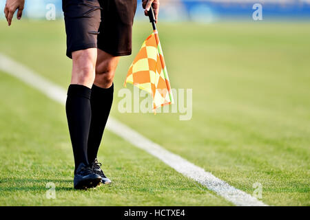 Arbitro assistente in movimento lungo il diversivo durante una partita di calcio Foto Stock