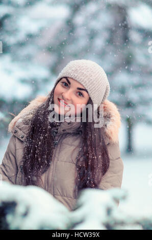 Giovane donna che indossa un cappotto all'aperto nella neve Foto Stock