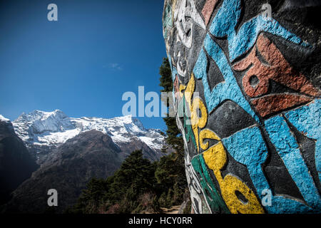 Una parete di Mani, inscritte con un antico mantra buddista decora il sentiero per il Campo Base Everest, Nepal Foto Stock