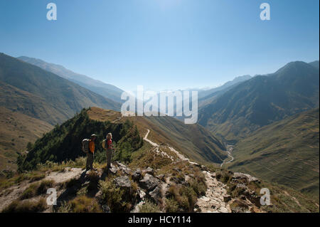 Prendendo una pausa dal percorso in corrispondenza di un punto di vista nella valle Juphal, Nepal Foto Stock