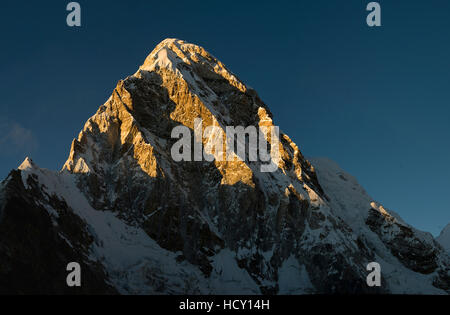 Tramonto mette in evidenza la forma drammatica del Pumori, visto qui da Kala Patar, Khumbu, in Nepal Foto Stock