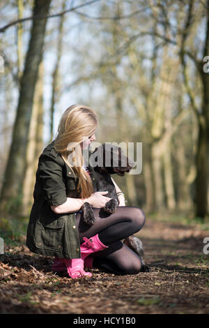 Una ragazza prende il suo tedesco a pelo corto puntatore per una passeggiata nei boschi vicino a Ashmore in Dorset, Regno Unito Foto Stock