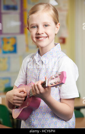 Ragazza imparare a suonare Ukulele a scuola lezione di musica Foto Stock