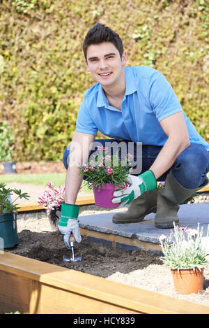 Paesaggio giardiniere Semina letto di fiori nel giardino Foto Stock