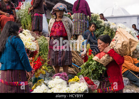 Quiche Maya della donna in abito tradizionale che vendono fiori sui gradini della chiesa di Santo Tomas a Chichicastenango, Guatemala. Diverse donne visib Foto Stock