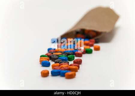Caramelle colorate a forma di teschi svuotato dalla sacca isolata. Foto Stock