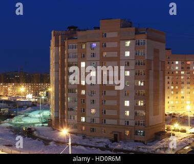 Un edificio a più piani in serata in inverno contro il cielo blu Foto Stock