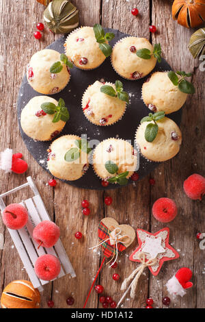 Natale muffin ai mirtilli decorate con la menta vicino sul tavolo. vista verticale da sopra Foto Stock