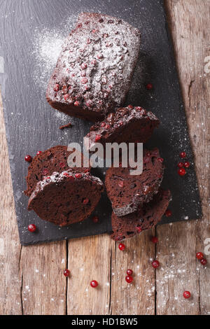 Fette di torta al cioccolato ripiene con mirtilli rossi vicino sul tavolo. vista verticale da sopra Foto Stock