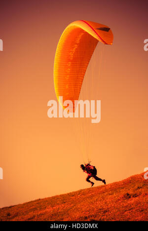 Parapendio volare al cielo arancione a Bielsko Biala Zar montagna in Polonia Foto Stock