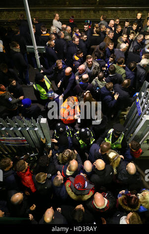 Gli ufficiali di polizia tenere indietro i tifosi di calcio che sono attendere cercando di inserire Falmer railway station per un treno del sud dopo la Brighton e Hove Albion v Leeds United Sky scommessa match del campionato al AMEX Stadium, Brighton. Foto Stock