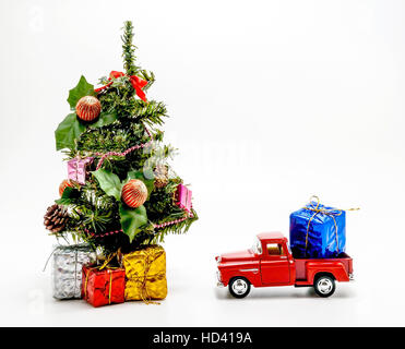 Retro rosso giocattolo auto porta una scatola con un regalo per albero di Natale. Foto Stock