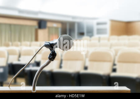 Supporto del microfono sul podio con sfocatura astratto foto della sala conferenze o sala seminario in background. Seminario aziendale concetto. Foto Stock