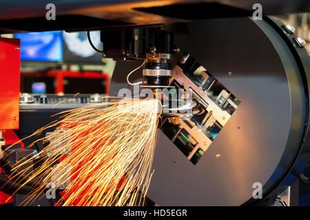 CNC taglio laser tubo metallico con un luminoso sparkle in fabbrica. L'industria della macchina. Foto Stock