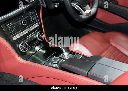 Rosso auto di lusso interno con il volante, la leva del cambio e aria condizionata e controllo pulsante di opzione in auto Foto Stock