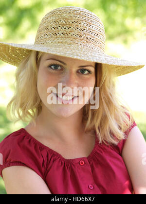 Giovane donna che indossa un cappello di paglia Foto Stock