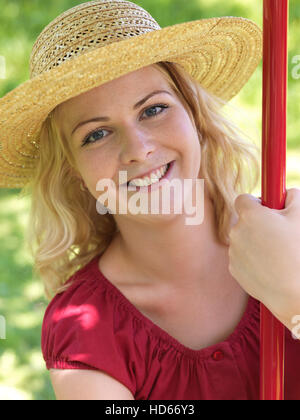 Giovane donna che indossa un cappello di paglia Foto Stock