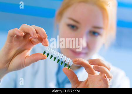 Modello rilasciato. Giovane donna azienda provette per PCR. Foto Stock