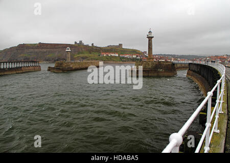 Whitby parete del porto e il lungomare, faro e alla vista dell'Abbazia Foto Stock