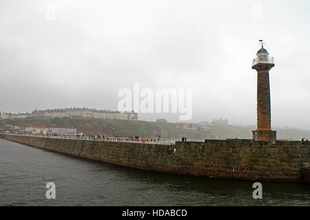 Whitby parete del porto e il lungomare, faro e vista città Foto Stock