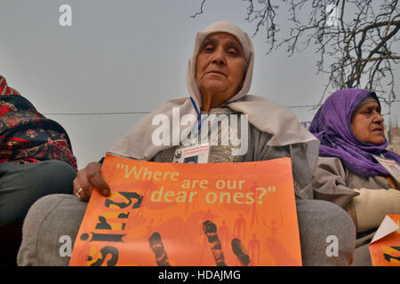 Srinagar Kashmir. 10 dicembre, 2016. Una donna del Kashmir il cui rispetto è scomparso detiene una targhetta in corrispondenza di un contrassegno di protesta la Giornata Internazionale dei Diritti Umani a Srinagar, Indiano Kashmir amministrato sul dicembre 10, 2016 © Saqib Majeed/Alamy Live News Credito: Saqib Majeed/Alamy Live News Foto Stock