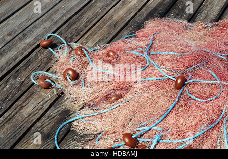 Corda arancione reti da pesca su un molo in legno . Foto Stock