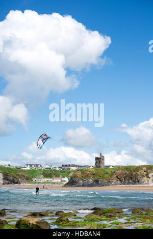 Lone kite surfer equitazione con le onde a ballybunion spiaggia sul selvaggio modo atlantico Foto Stock