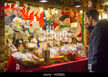 COMO, Italia - 2 dicembre 2016: uomo sceglie dalla varietà di formaggio in inverno Mercatino di Natale Foto Stock
