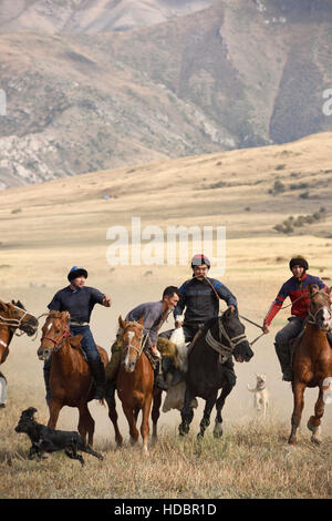 Due uomini a cavallo in lotta per carcassa di capra nel gioco di Kokpar Tudabarai Aksu Zhabagly Kazakistan Foto Stock