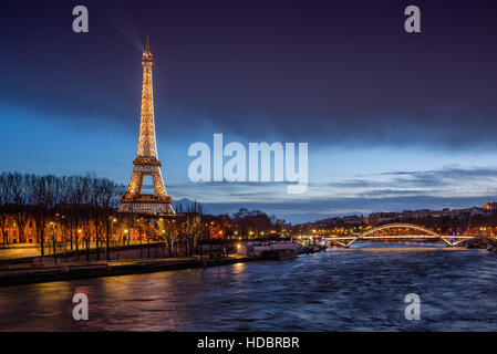 La Torre Eiffel illuminata al crepuscolo con sponde della Senna e la passerella Debilly. Parigi, Francia Foto Stock