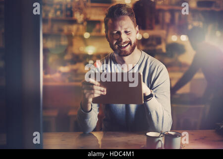 Imprenditore nel cafe utilizzando tablet di notte Foto Stock